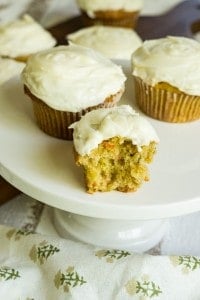 carrot cupcakes on cake stand with bite taken out.