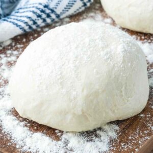 ball of homemade pizza dough sprinkled with flour.
