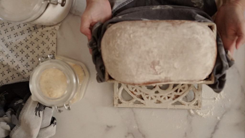 taking baked sourdough sandwich bread out of the oven
