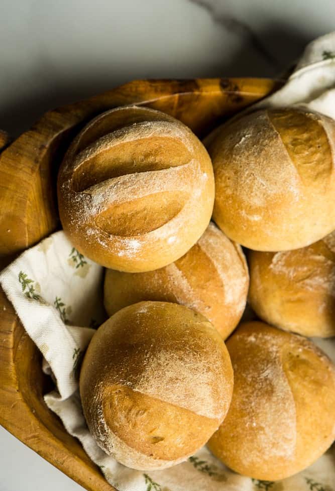 close up view of tops of honey wheat rolls they are all slashed