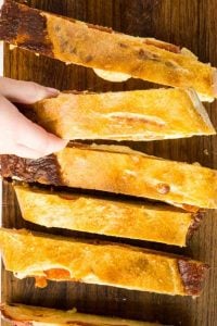 slices of pepperoni bread with hand reaching for one.
