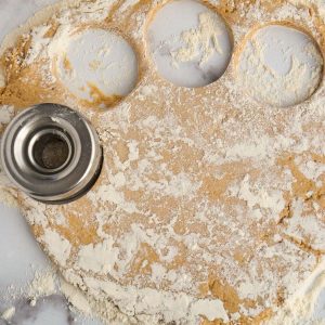 rolled out doughnut dough being cut out