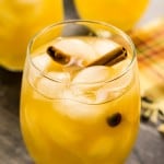 glass of fall sangria with ice and cinnamon sticks
