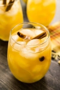 glass of fall sangria with ice and cinnamon sticks