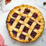 lattice-topped berry pie on marble counter.