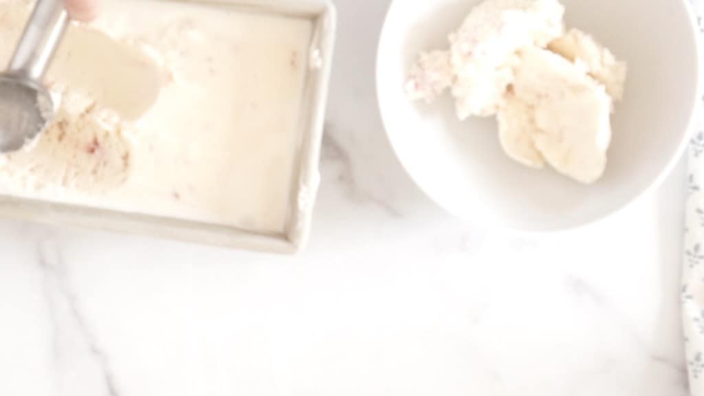 homemade candy cane ice cream being scooped out of container