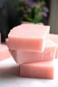 three bars of pink soap stacked on marble counter