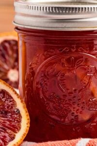 close up of jar of marmalade with blood orange beside.