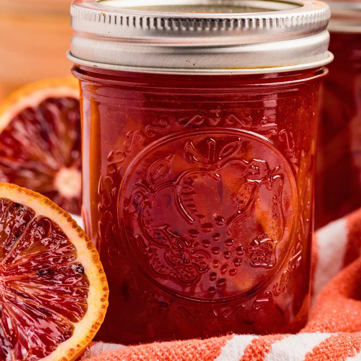 half-pint jar of deep red marmalade with blood orange beside.