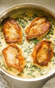 stainless steel pan with pork chops and spinach