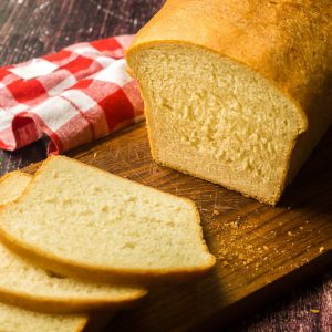loaf of milk and honey sandwich bread on wooden cutting board