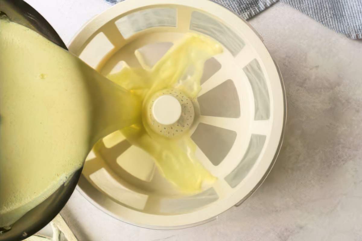 Straining custard mixture through a fine mesh strainer into a bowl