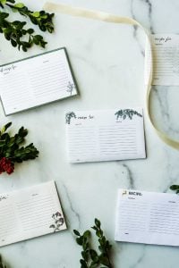5 recipe cards on marble surface with greenery