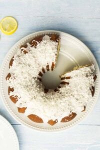 bundt cake with white icing and shredded coconut on top.