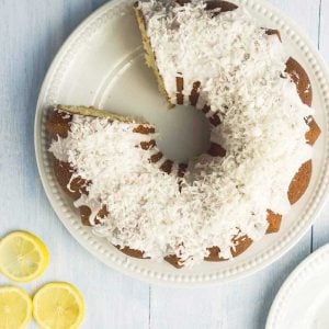 Bundt Cake topped with flaked coconut with slice missing