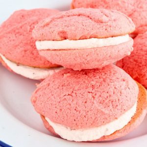 large pink sandwich cookies on plate