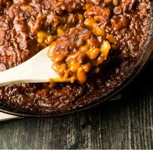 close up of scoop of baked beans in skiller