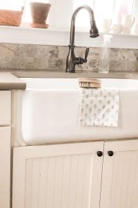 white fireclay sink with cream cabinets