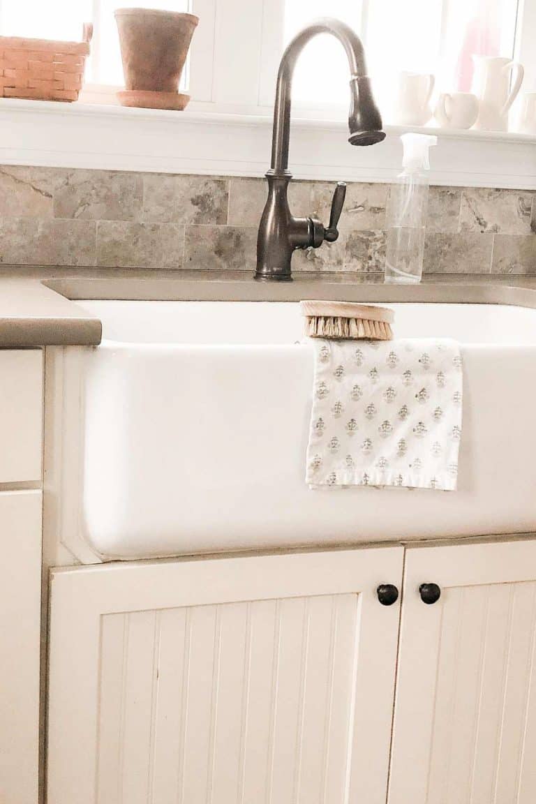 white fireclay sink with cream cabinets