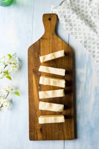 overhead view of sliced bars of off white soap on cutting board