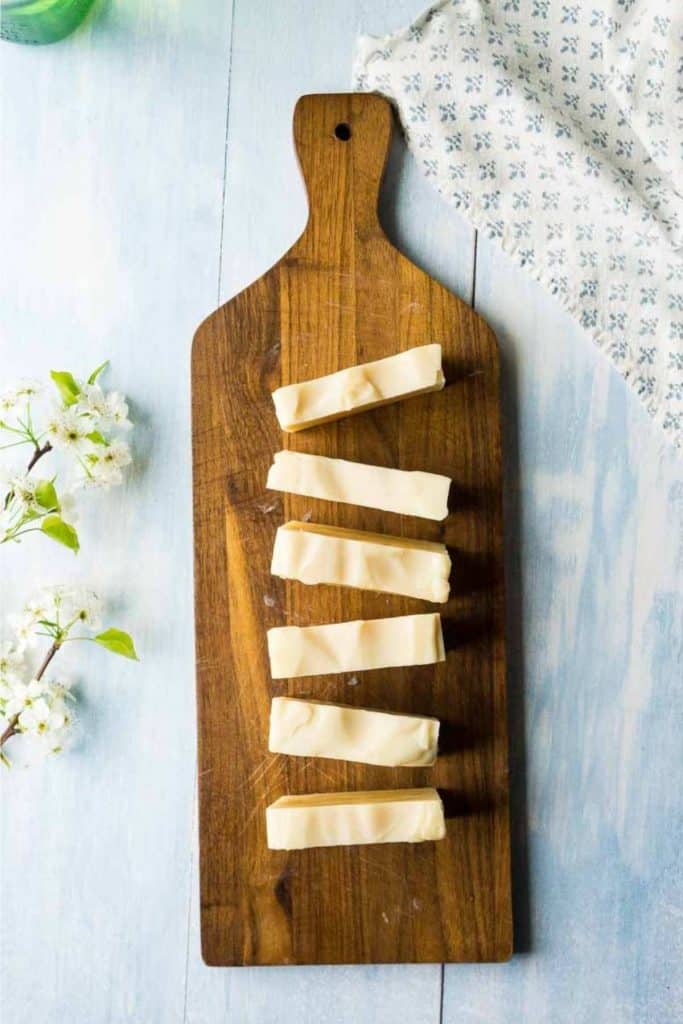 overhead view of sliced bars of off white soap on cutting board