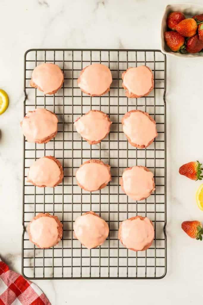 12 strawberry frosted cookies on cooling rack