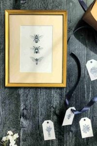 framed bee print and tag on wooden background