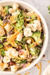 white bowl of broccoli salad with cauliflower