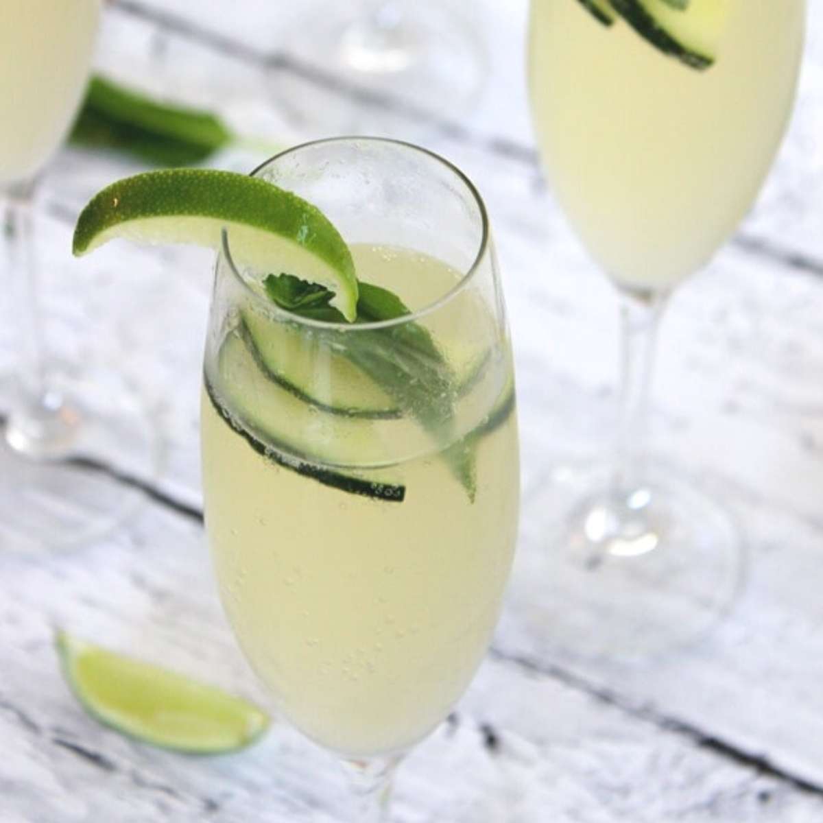 champagne glasses with lime and cucumber cocktail