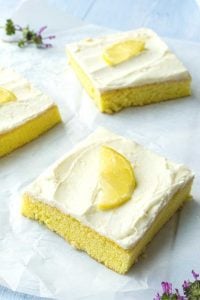 squares of lemon cake with slice of fresh lemon on top