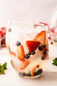 glass of prosecco sangria with fruit and mint leaves