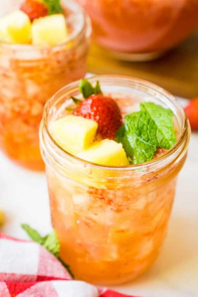 2 glasses of strawberry pineapple cocktail on white counter