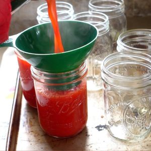 canning jars being filled with concentrate