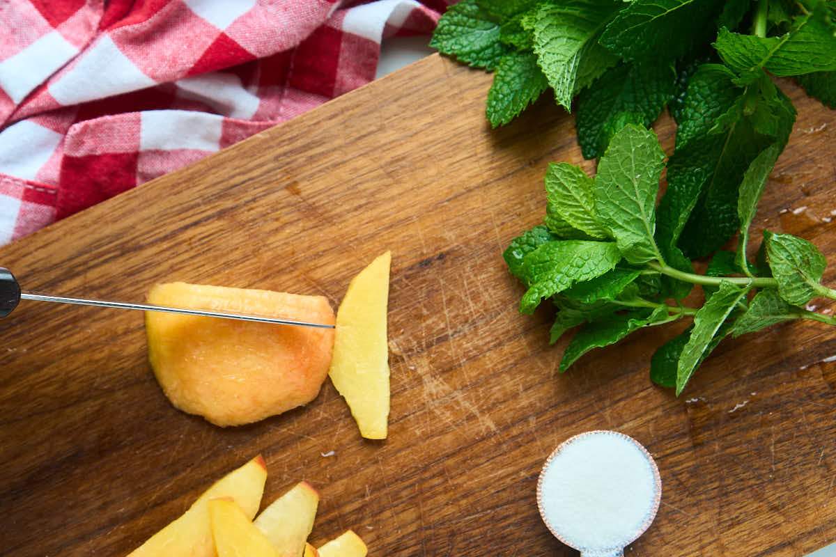 slicing peaches on cutting board.