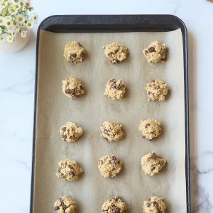 scoops of cookie dough on parchment lined sheet