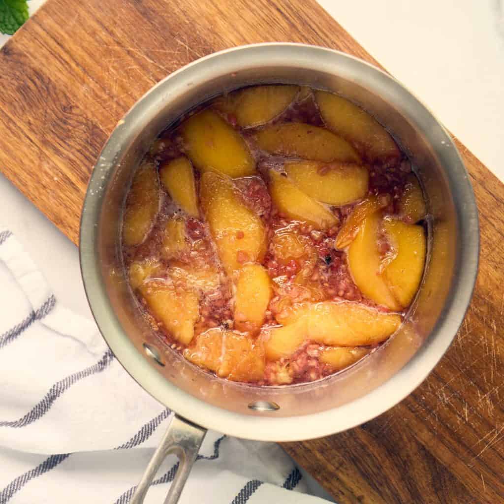 cooked peaches and raspberies in small saucepan