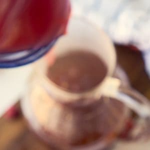 pouring fruit syrup into tea