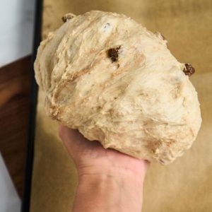 hand stretching dough into a ball