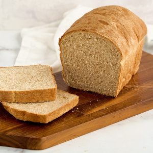 loaf of honey wheat bread on cutting board