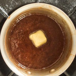 pat of butter on top of fudge in saucepan