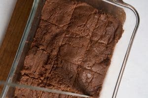 glass dish of homemade fudge being cut into squares