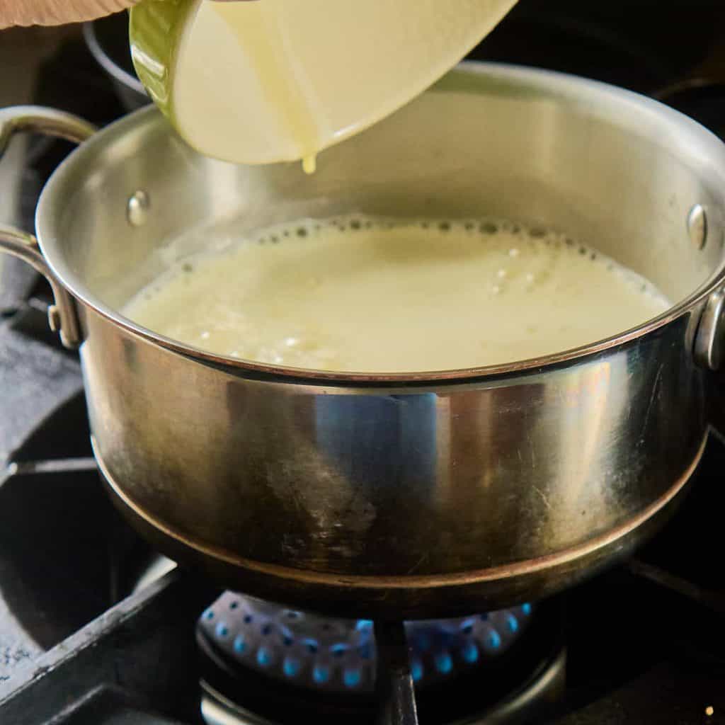 pouring custard into saucepan