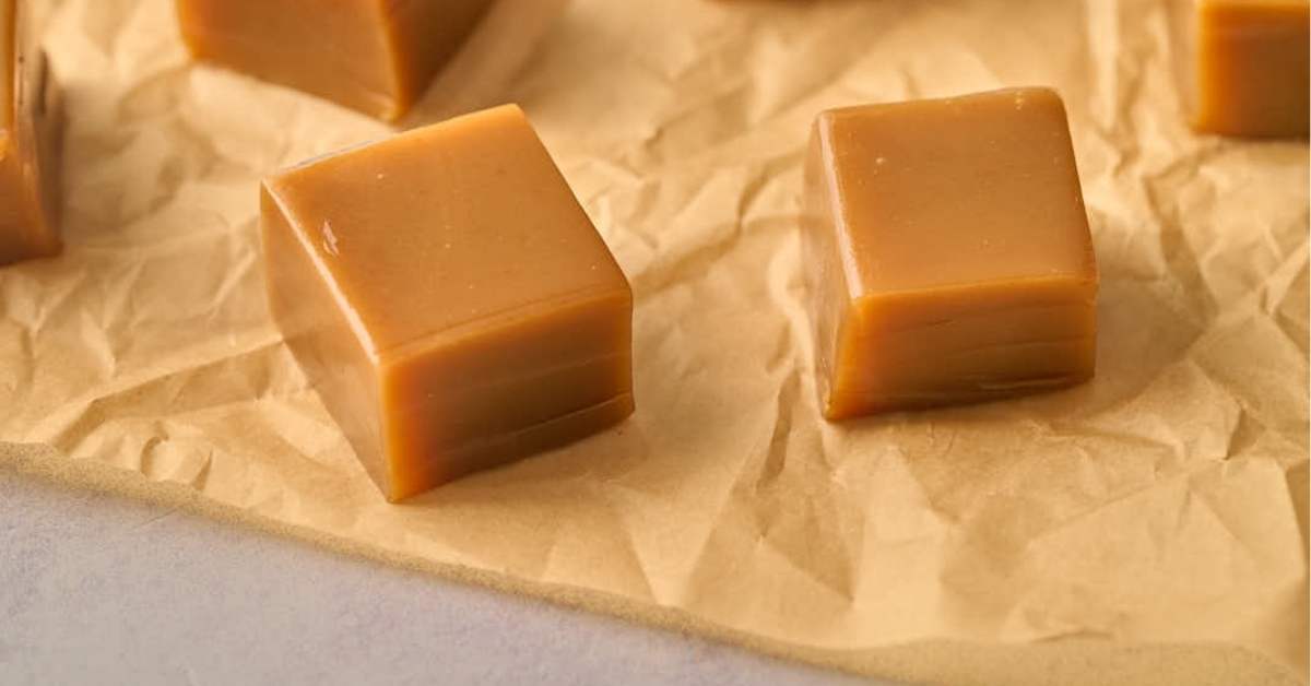two squares of caramel on parchment paper.