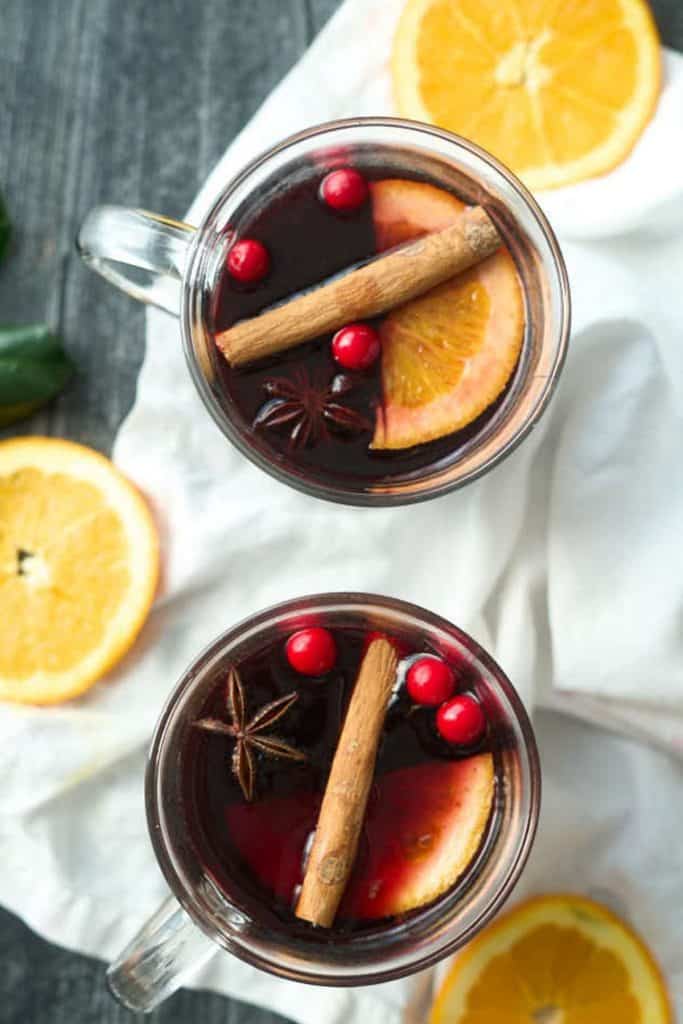 2 cups mulled red wine in clear mug with cinnamon sticks