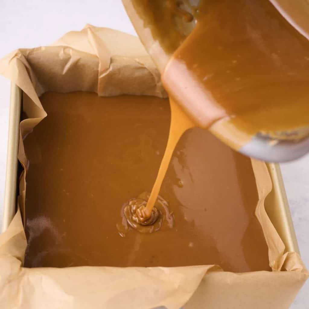 saucepan pouring caramel into dish