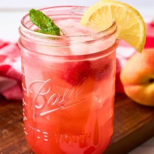 mason jar with pink lemonade made from peaches and raspberries