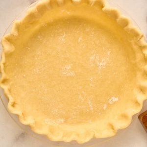 crimped pastry pie crust in glass plate