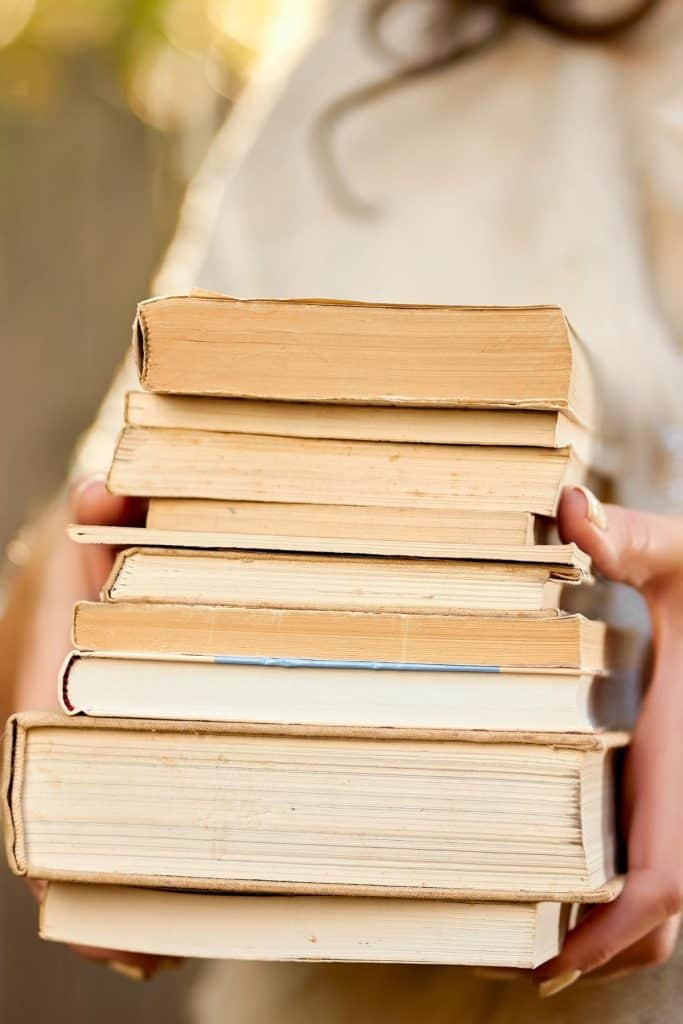 stack of cookbooks in hand