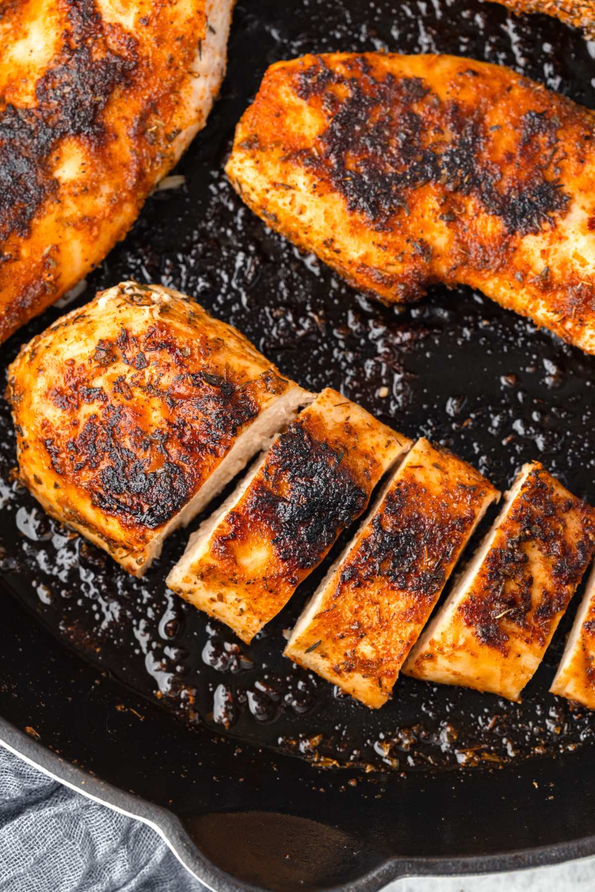 overhead view of chicken breast blackened in skillet.