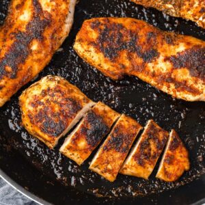 close up view of chicken breast in skillet.